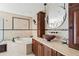 Elegant bathroom with soaking tub, custom vanity, and tiled walls at 5239 Siesta Cove Dr, Sarasota, FL 34242