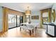 Bright dining room with white table set, hardwood floors, and sliding doors to outdoor living space at 5239 Siesta Cove Dr, Sarasota, FL 34242