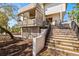 Home's front entrance shows a staircase and porch, with wood and neutral color accents at 5239 Siesta Cove Dr, Sarasota, FL 34242