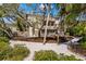 Beautiful exterior view with lush tropical landscaping and a classic multi-story home design at 5239 Siesta Cove Dr, Sarasota, FL 34242