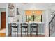 Kitchen featuring marble countertops, custom bar with stools, stainless steel appliances, and hardwood floors at 5239 Siesta Cove Dr, Sarasota, FL 34242