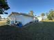 Wide view of the rear of the house showing a spacious backyard with mature trees at 690 Ennis Nw Ter, Port Charlotte, FL 33952