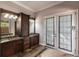 Dual sink bathroom with custom cabinetry, natural stone, and walkout access to the exterior at 7440 Riverside Dr, Punta Gorda, FL 33982