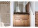 Bathroom vanity with storage cabinets, decorative tile accents, granite countertops, and a framed mirror at 7440 Riverside Dr, Punta Gorda, FL 33982