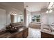 Bathroom with dual sinks, granite countertop, tiled floor, decorative lighting and a tub near a window at 7440 Riverside Dr, Punta Gorda, FL 33982