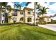 Luxury home featuring lush landscaping, a manicured lawn, and an elegant entryway at 7440 Riverside Dr, Punta Gorda, FL 33982