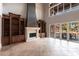 Living room with built-in shelves, a stone fireplace, and floor-to-ceiling windows overlooking the backyard patio at 7440 Riverside Dr, Punta Gorda, FL 33982