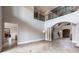 Open living room with a staircase, stone columns, an archway, and tiled floors with floor-to-ceiling windows at 7440 Riverside Dr, Punta Gorda, FL 33982