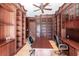 Home office boasts custom wood shelving, wood floors, ceiling fan and space for a desk in the center at 7440 Riverside Dr, Punta Gorda, FL 33982