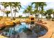 Beautiful backyard with a custom pool featuring a rock grotto and lush landscaping at 7440 Riverside Dr, Punta Gorda, FL 33982