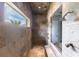 Walk-in shower with multiple shower heads, natural stone, and accent window at 7440 Riverside Dr, Punta Gorda, FL 33982