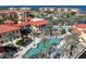 Aerial view showcases the community pool, lush landscaping, and Mediterranean-style architecture near the water at 85 Vivante Blvd # 8542, Punta Gorda, FL 33950