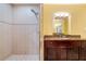 Well-lit bathroom featuring a tiled shower with glass enclosure and a vanity with a dark wood cabinet at 85 Vivante Blvd # 8542, Punta Gorda, FL 33950