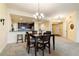 Cozy dining area with a dark wood table, stylish chandelier, and a view into the kitchen and entry hall at 85 Vivante Blvd # 8542, Punta Gorda, FL 33950