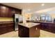 Open kitchen design with tile flooring, island, stainless steel refrigerator, and dark wood cabinets at 85 Vivante Blvd # 8542, Punta Gorda, FL 33950