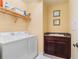 Bright laundry room with a washing machine, dryer, and a utility sink with a dark wood cabinet at 85 Vivante Blvd # 8542, Punta Gorda, FL 33950