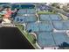 Aerial view of multiple tennis courts within a community, surrounded by lush landscaping and a tranquil lake at 85 Vivante Blvd # 8542, Punta Gorda, FL 33950