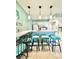 Kitchen bar with three stools, pendant lighting, and white cabinetry at 9400 Little Gasparilla Is # C2, Placida, FL 33946