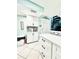 Well-lit kitchen with white cabinets, tiled backsplash, and a breakfast bar, offering a clean, modern design at 9400 Little Gasparilla Is # C2, Placida, FL 33946