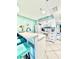 Stylish kitchen features white cabinets, a breakfast bar with seating, and vibrant turquoise accents at 9400 Little Gasparilla Is # C2, Placida, FL 33946