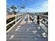 A wooden dock stretches out with an American flag waving on a serene, sunny day at 9400 Little Gasparilla Is # C2, Placida, FL 33946