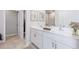 Spacious bathroom with double sinks, white cabinets, modern fixtures, and tiled floors offering a contemporary design at 9519 Turtle Grass Cir, Punta Gorda, FL 33950