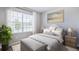 Bright bedroom with a large window, decorative pillows, and modern lamps at 9519 Turtle Grass Cir, Punta Gorda, FL 33950