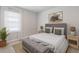 Comfortable bedroom with neutral decor, two lamps and a large window at 9519 Turtle Grass Cir, Punta Gorda, FL 33950