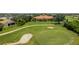 An aerial view displays a community center with a golf course, lake, and sand traps nearby at 10488 Princess Ct, Punta Gorda, FL 33955