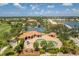 Aerial view of community pool, tennis courts, lake, golf course and clubhouse with water tower in the background at 10488 Princess Ct, Punta Gorda, FL 33955