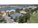 Aerial view of tennis courts and swimming pool, with the lake and golf course in the background at 10488 Princess Ct, Punta Gorda, FL 33955