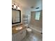 Bathroom featuring a granite-topped vanity, tiled floors, a tub-shower combo, and a glass block window at 1051 Forrest Nelson Blvd # M 103, Port Charlotte, FL 33952