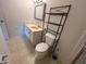 Bathroom with tiled floors, a large vanity, and a decorative shelf above the toilet at 1051 Forrest Nelson Blvd # M 103, Port Charlotte, FL 33952