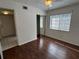 Bedroom with wood flooring, large window, ceiling fan, and sliding closet doors at 1051 Forrest Nelson Blvd # M 103, Port Charlotte, FL 33952