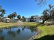 View of pond reflecting the building on a sunny day with palms and grass at 1051 Forrest Nelson Blvd # M 103, Port Charlotte, FL 33952