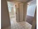 Bright hallway features white tile floors, access to a bathroom, and a bi-fold closet at 1051 Forrest Nelson Blvd # M 103, Port Charlotte, FL 33952
