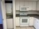Efficiently designed kitchen offers stacked washer/dryer and white appliances and cabinets at 1051 Forrest Nelson Blvd # M 103, Port Charlotte, FL 33952