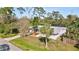 An aerial view showcases this single-story home surrounded by lush trees, a screened in lanai and a long private driveway at 1052 Archer St, Port Charlotte, FL 33952