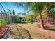 Spacious backyard with screened-in porch, mature trees, and storage shed at 1052 Archer St, Port Charlotte, FL 33952