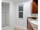Bright bathroom featuring tiled shower, single window, and traditional vanity with granite countertop at 1052 Archer St, Port Charlotte, FL 33952