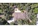 Aerial view of a home with a unique roof design, surrounded by mature trees and lush greenery at 1055 & 1075 Yorkshire St St, Port Charlotte, FL 33952