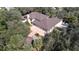 Expansive house with a brown roof, lush trees, and a circular gazebo with a small garden at 1055 & 1075 Yorkshire St St, Port Charlotte, FL 33952