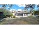 Rear view of home featuring an expansive sunroom with abundant windows and a generous backyard at 1055 & 1075 Yorkshire St St, Port Charlotte, FL 33952