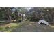 The backyard of the property is very large and features mature trees, other foliage, and a boat at 1055 & 1075 Yorkshire St St, Port Charlotte, FL 33952