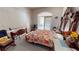 A bedroom featuring a large bed with an ornate headboard and a floral bedspread, with doors leading outside at 1055 & 1075 Yorkshire St St, Port Charlotte, FL 33952