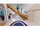 Bright entryway features white tile floors, a wooden staircase, and elegant decor at 1055 & 1075 Yorkshire St St, Port Charlotte, FL 33952