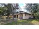 Two-story home with a mix of beige stucco and brick, accented by large trees and a green lawn at 1055 & 1075 Yorkshire St St, Port Charlotte, FL 33952