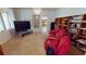 Inviting living area with a comfy red sofa, bookcases, and tree views from the window at 1055 & 1075 Yorkshire St St, Port Charlotte, FL 33952