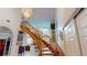 Wooden staircase with curved railings, leading to an open area with arched windows and natural light at 1055 & 1075 Yorkshire St St, Port Charlotte, FL 33952