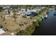 Aerial view of a property with a screened-in patio, boat dock, and waterfront access at 129 Barre Nw Dr, Port Charlotte, FL 33952